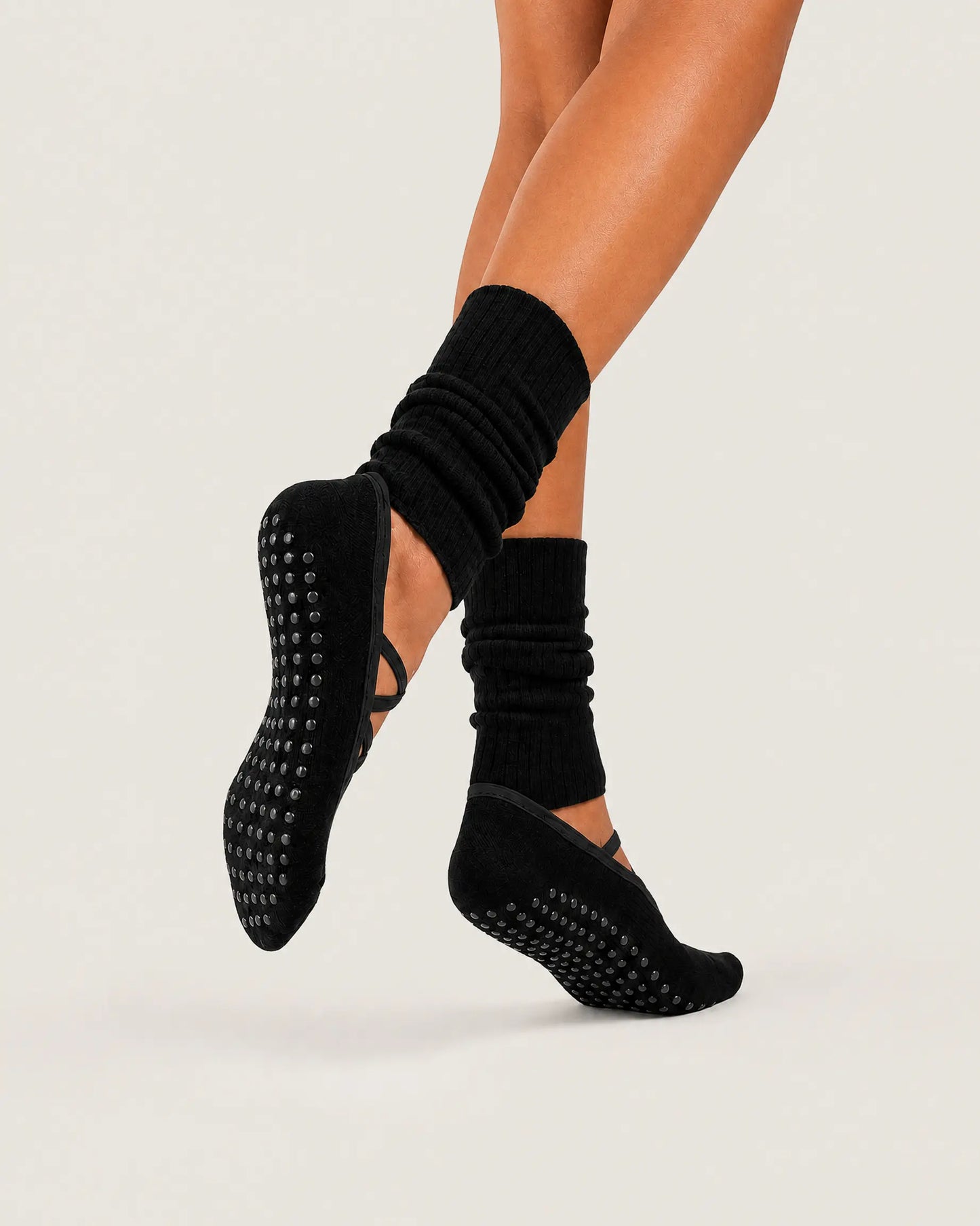 black | 04 | Black crisscross strap slouch grip socks action view showing the silicone full-sole grip, open instep, and tonal straps