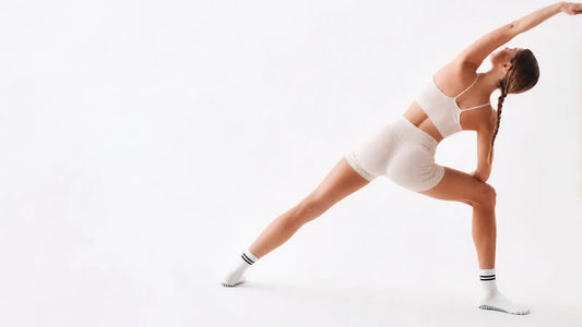 Woman wearing double-stripe five-toe grip socks during a studio stretch