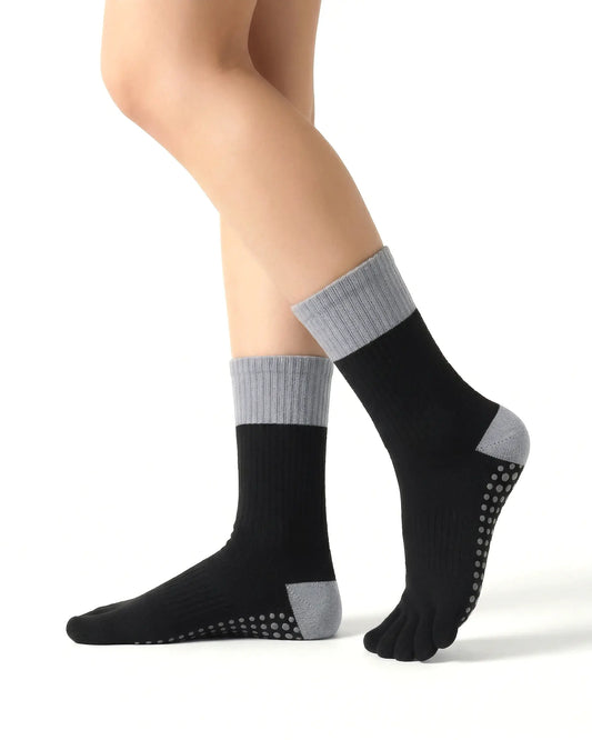 black | 01 | Black color block five-toe grip socks side standing view showing ribbed knit texture, contrast cuff and heel, and full-sole grip design