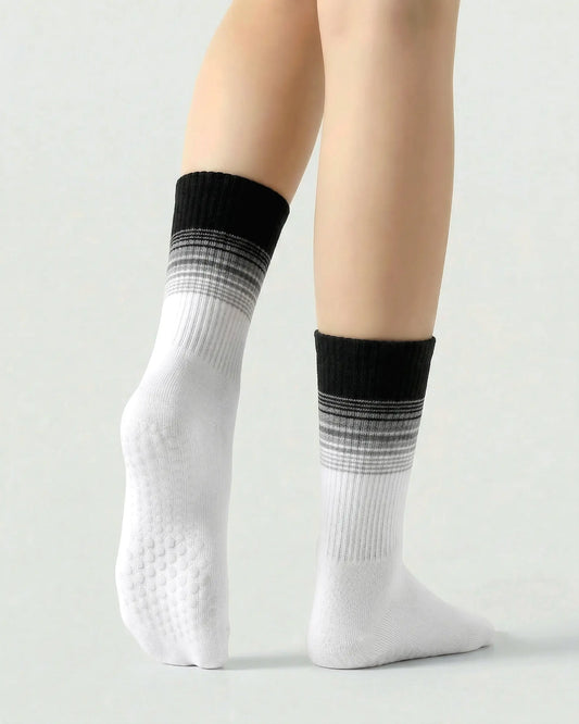 black-white | 02 | Crew grip socks tiptoe standing view showing black-white gradient striping, ribbed structure, and full sole grip coverage