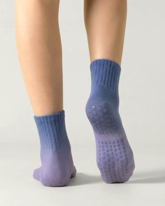 blue-purple | 02 | Blue purple gradient mid-crew grip socks back standing view showing heel-to-cuff gradient fade, ribbed structure, and full sole grip coverage