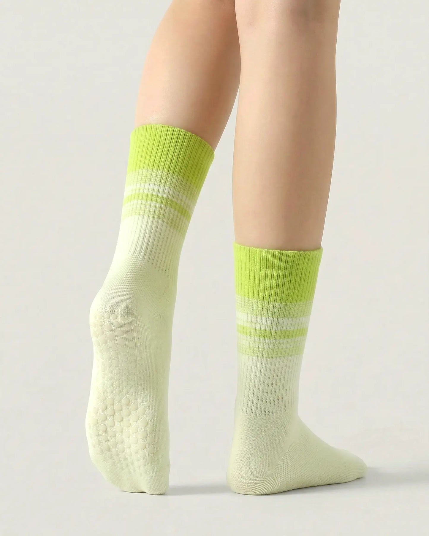 green | 02 | Crew grip socks tiptoe standing view showing green gradient striping, ribbed structure, and full sole grip coverage