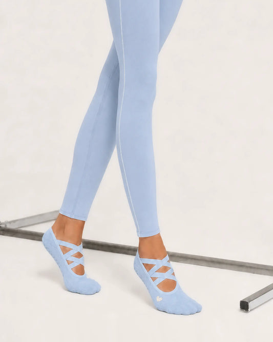 sky-blue | 02 | Sky blue Color-Pop Low-Cut Grip Socks side angled standing view showing the lightweight low-cut silhouette, crisscross straps, and covered heel