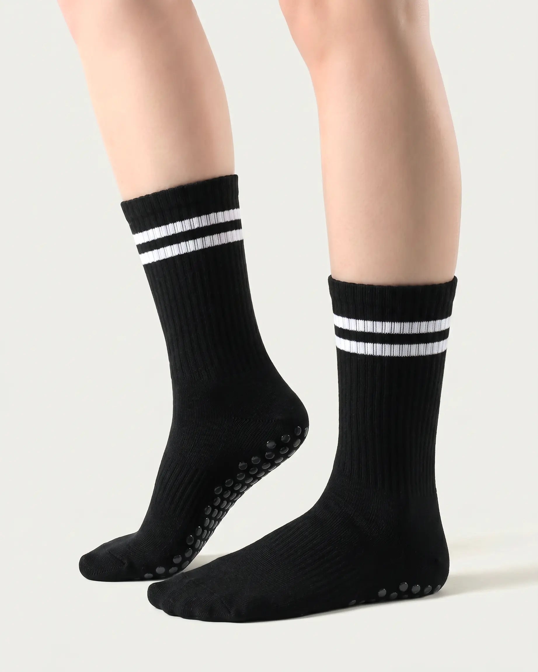 black| 01 | Black double-stripe crew grip socks side lift view showing ribbed texture, contrast stripe detail, and crew length