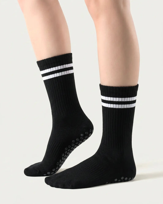 black| 01 | Black double-stripe crew grip socks side lift view showing ribbed texture, contrast stripe detail, and crew length