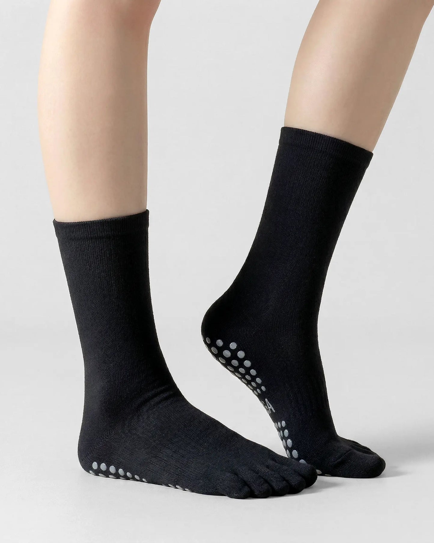 black | 01 | Black minimal five-toe grip socks side lift view showing clean texture, toe separation, and minimal studio look