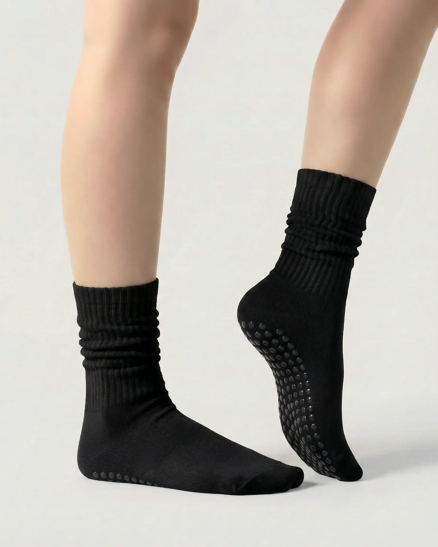 black | 03 | Black slouch grip socks side standing view showing relaxed slouch fit, ribbed knit texture, and minimal studio look