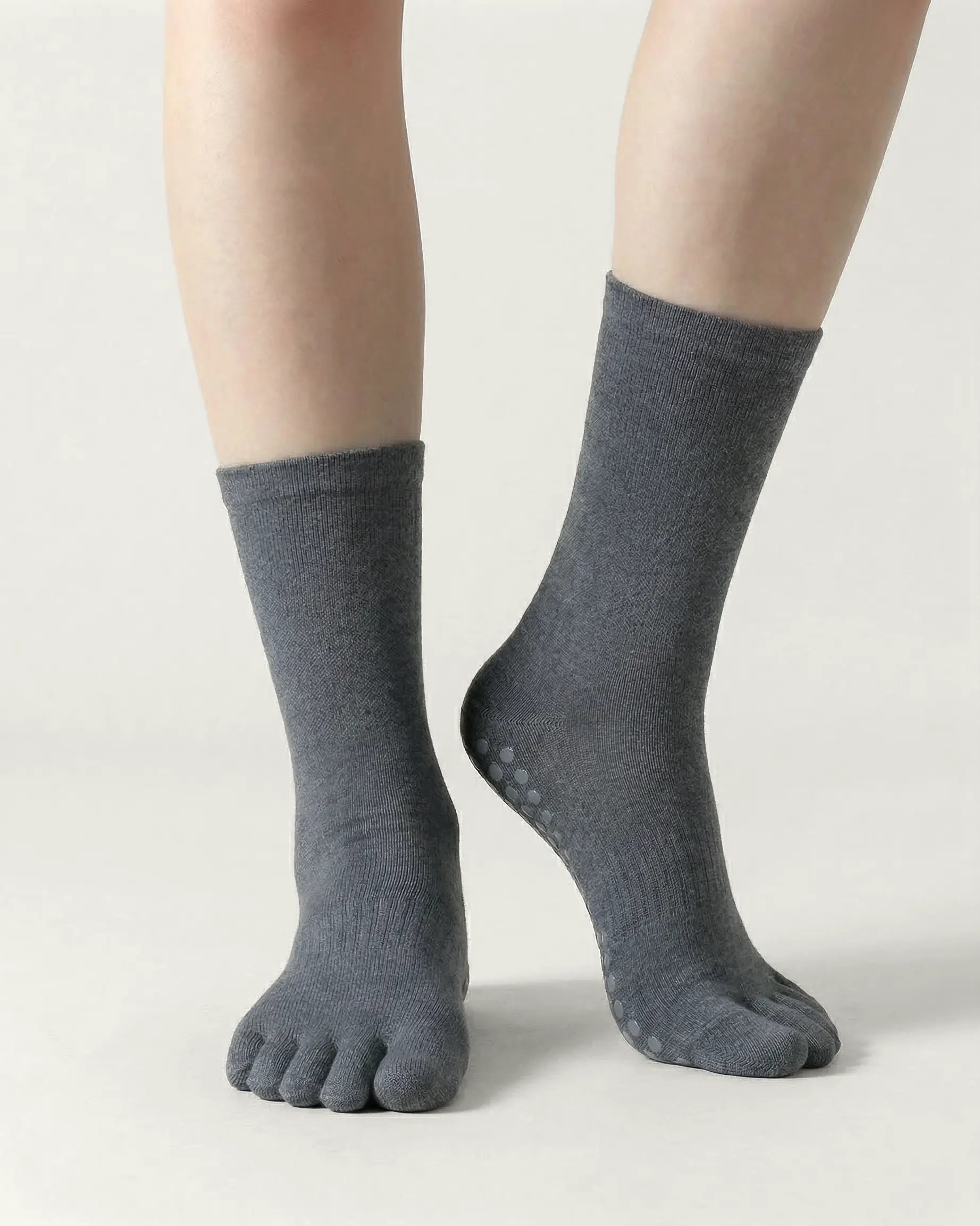 dark-grey | 04 | Dark-grey minimal five-toe grip socks front standing view showing toe separation, grip sole detail, and minimal silhouette