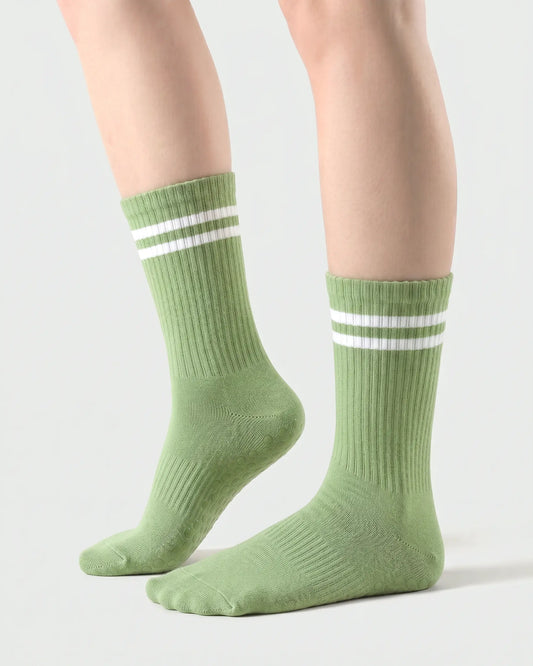 green | 01 | Green double-stripe crew grip socks side lift view showing ribbed texture, contrast stripe detail, and crew length