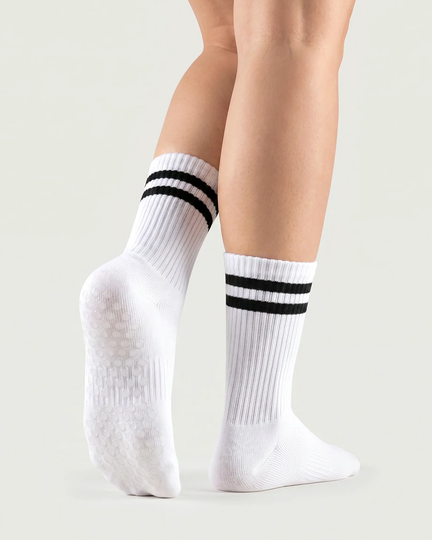 white | 02 | White double-stripe crew grip socks back view showing sole grip pattern, ribbed knit texture, and stripe detail