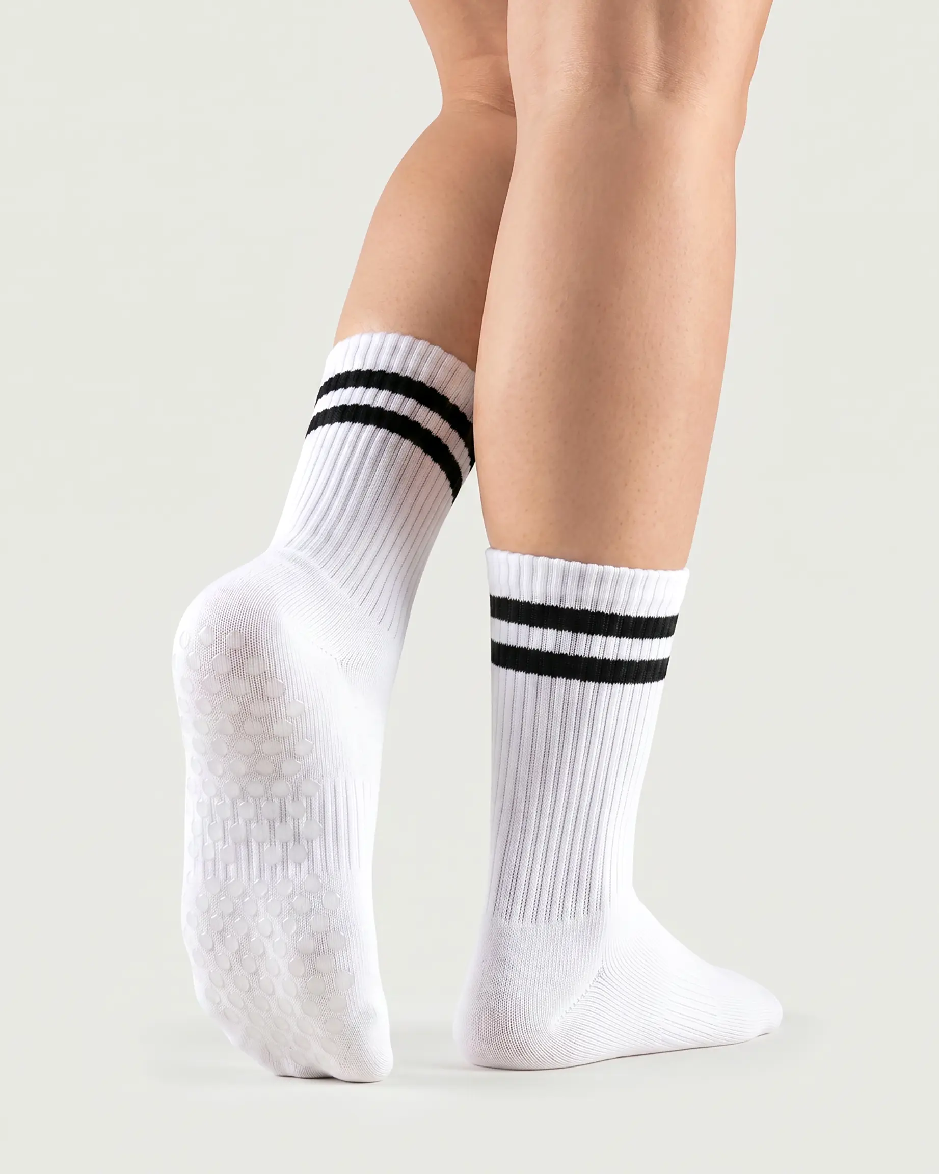 white | 02 | White double-stripe crew grip socks back view showing sole grip pattern, ribbed knit texture, and stripe detail