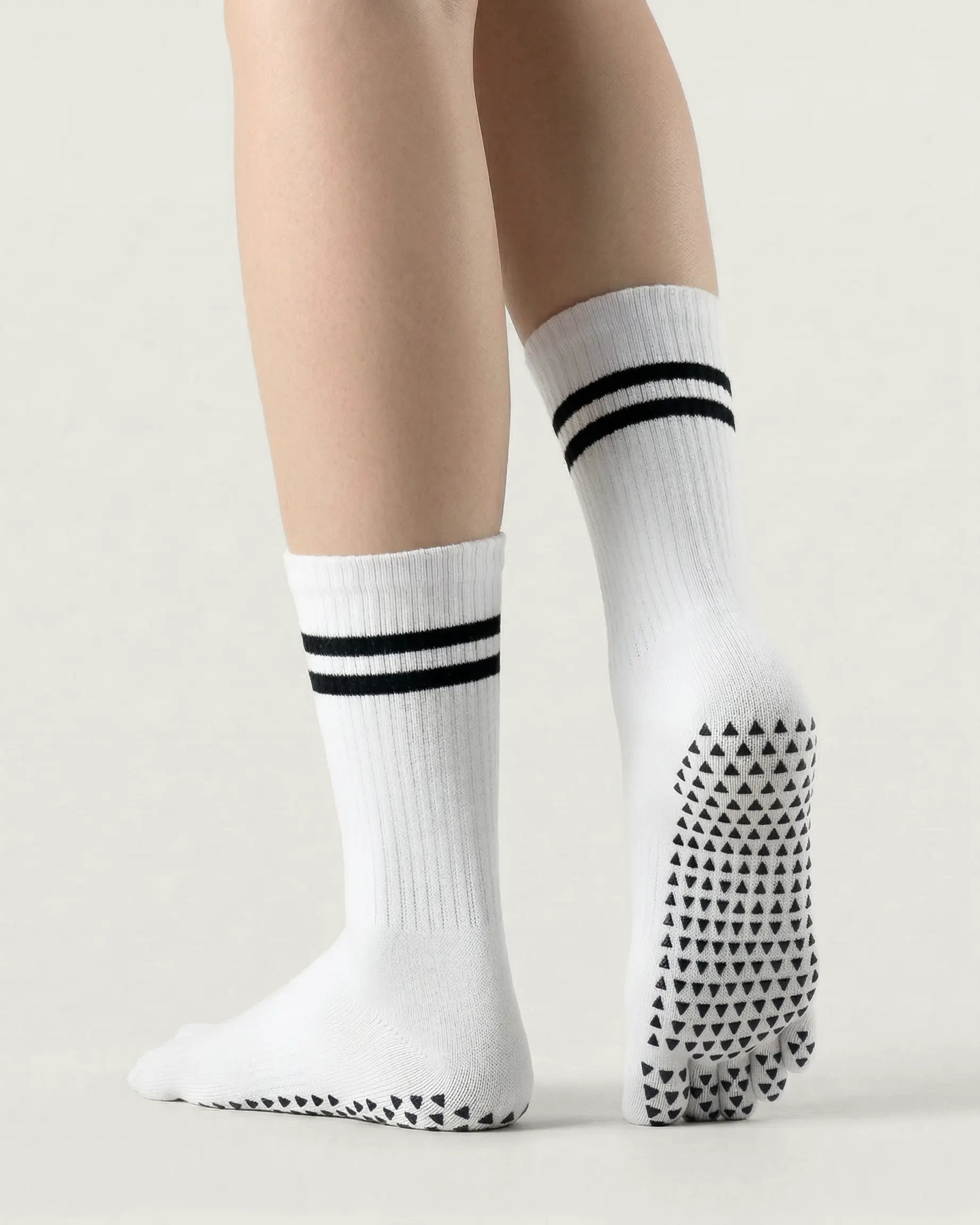 white | 02 | White double-stripe five-toe grip socks back view showing sole grip pattern, stripe detail, and ribbed knit texture