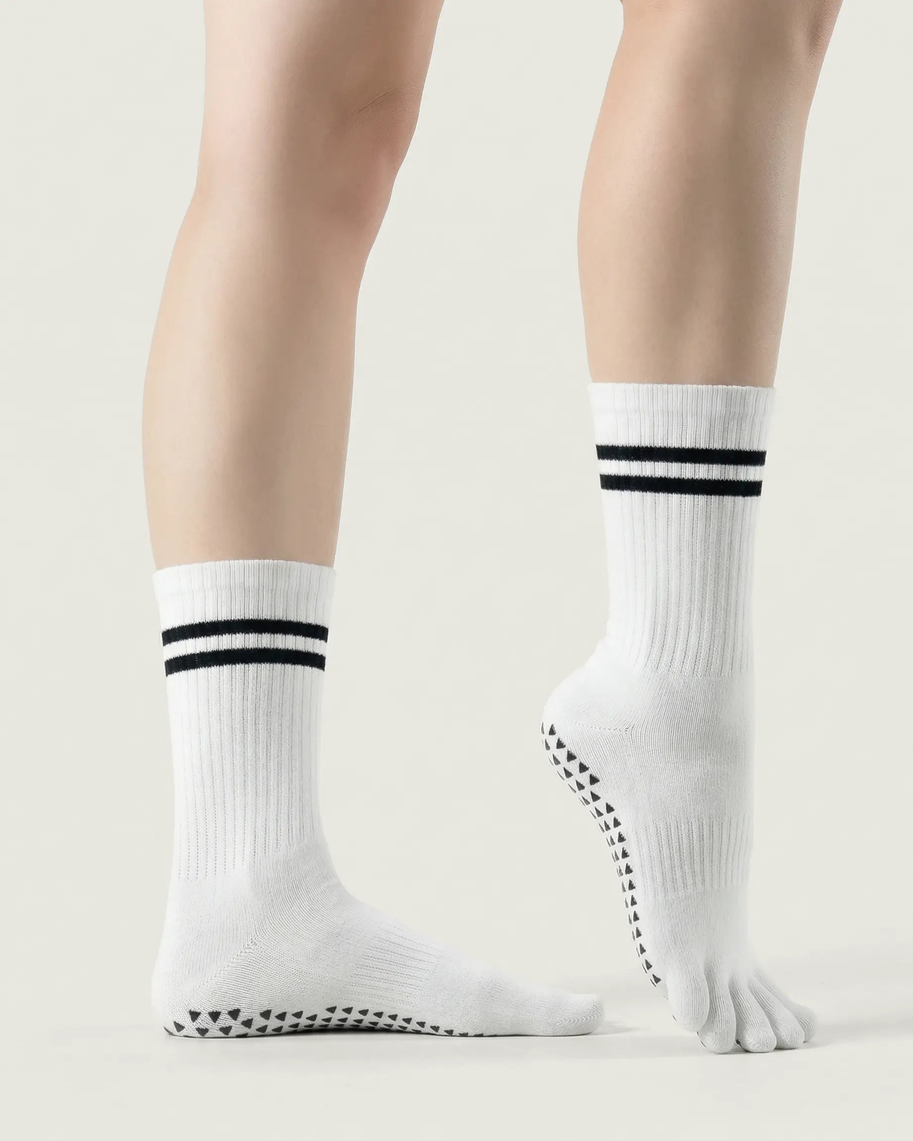 white | 03 | White double-stripe five-toe grip socks side standing view showing ribbed texture, stripe detail, and five-toe silhouette