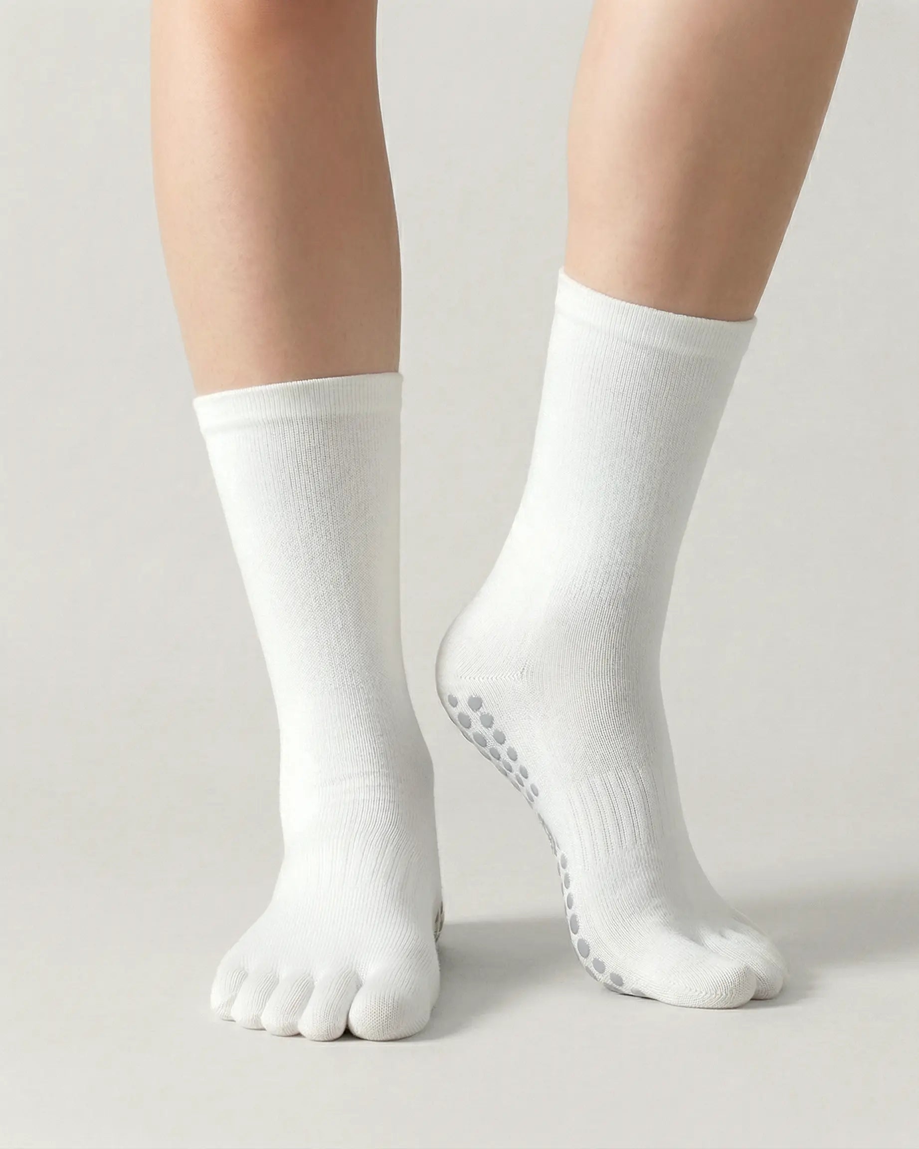 white | 04 | White minimal five-toe grip socks front standing view showing toe separation, grip sole detail, and minimal silhouette