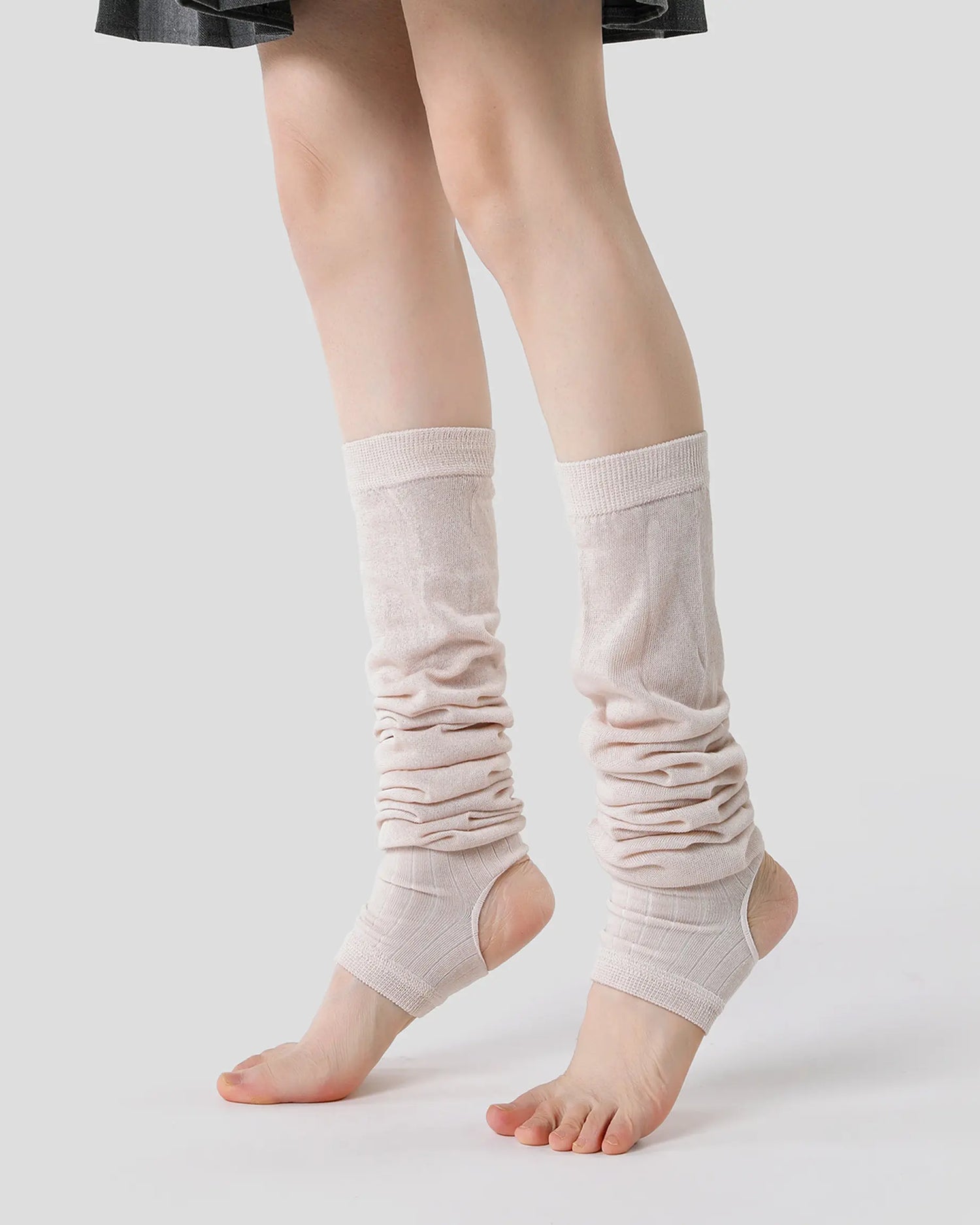 apricot | 01 | Apricot ballet stirrup leg warmers side angled standing view showing the open-heel stirrup shape, soft slouch folds, and ballet-inspired silhouette