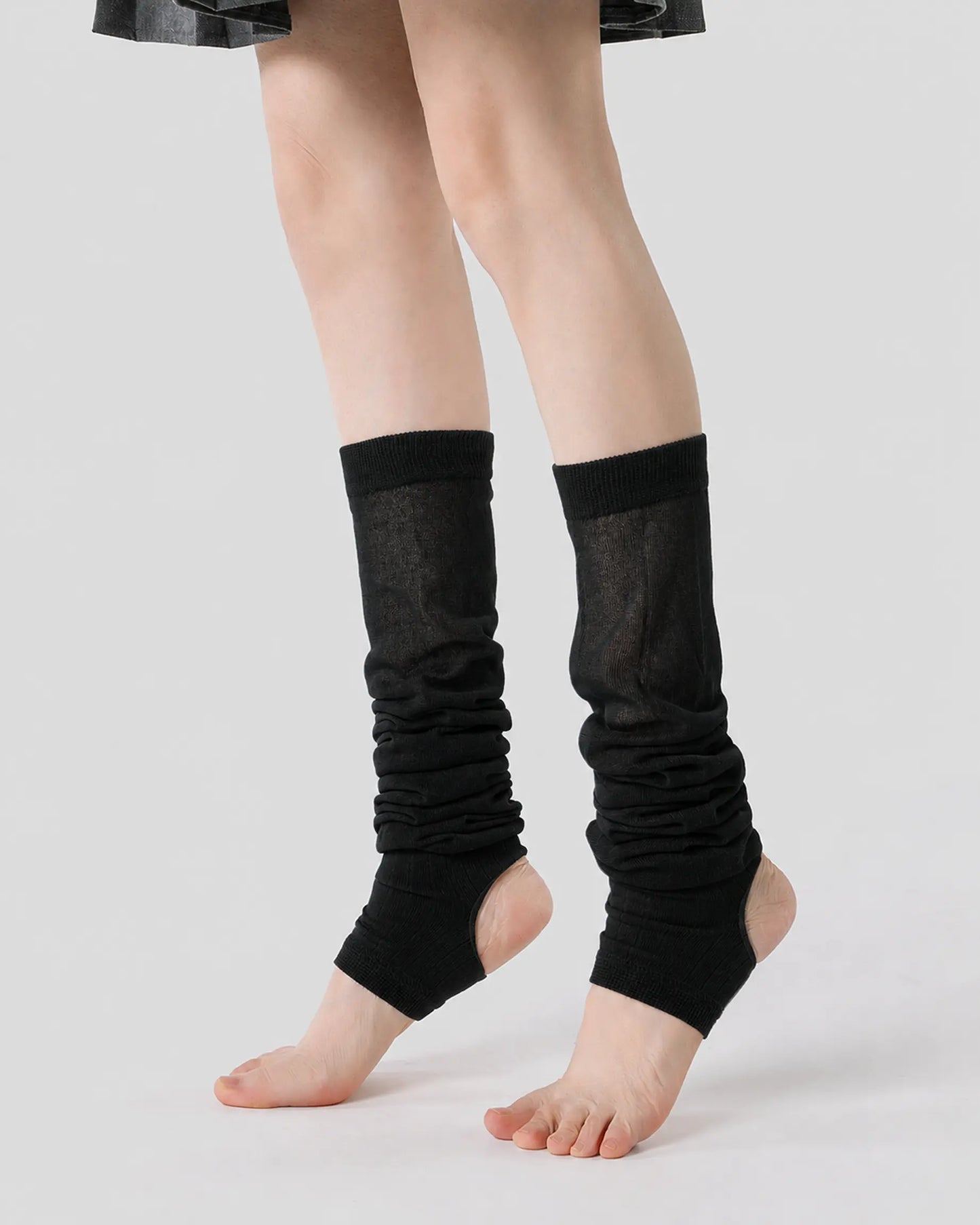 black | 01 | Black ballet stirrup leg warmers side angled standing view showing the open-heel stirrup shape, gathered slouch texture, and ballet-inspired silhouette