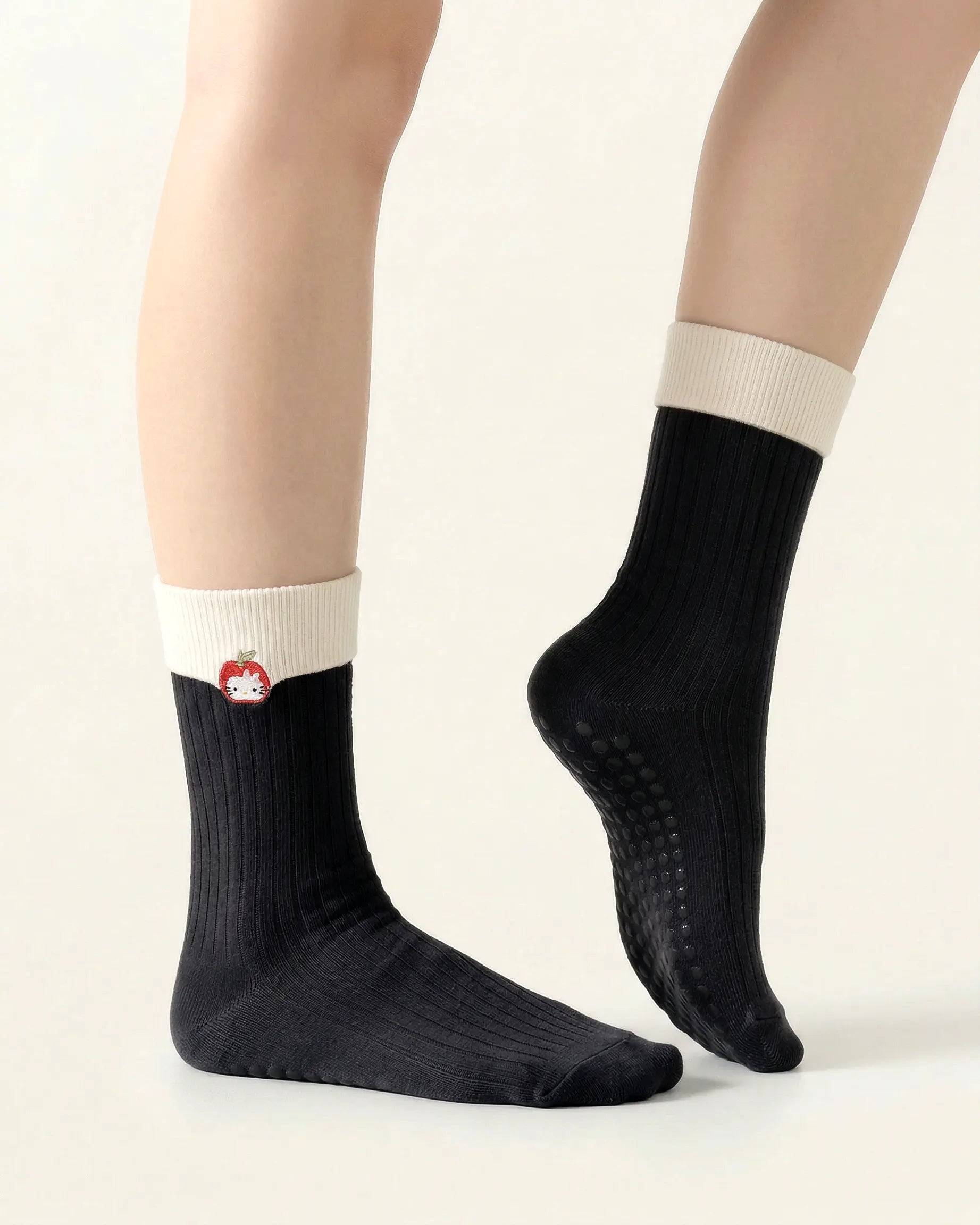 black | 03 | Black character embroidery crew grip socks side pointed standing view showing contrast cuff, clean crew silhouette, and cat embroidery detail