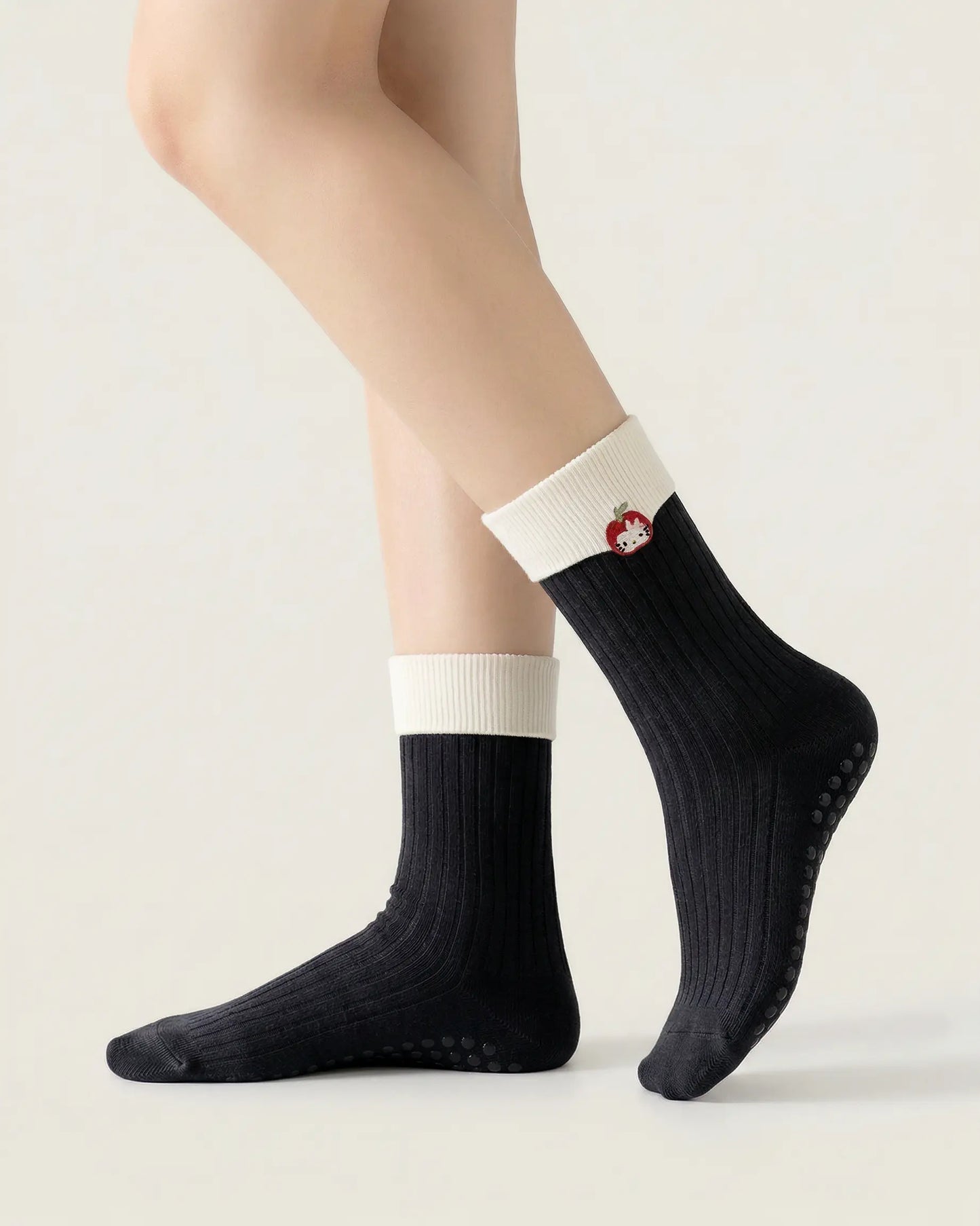 black | 01 | Black character embroidery crew grip socks side standing view showing contrast black cuff, ribbed knit texture, and cat embroidery detail