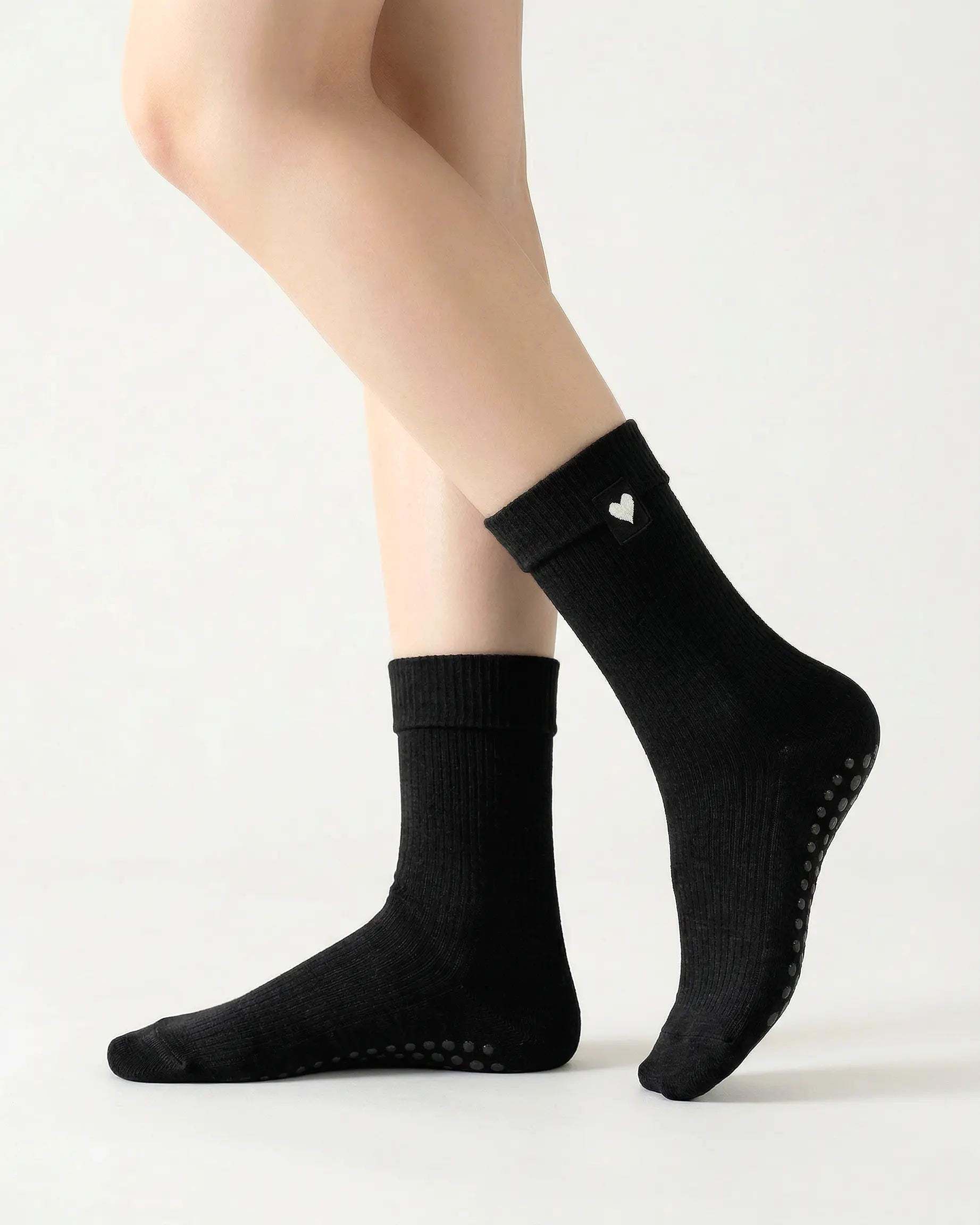 black | 01 | Black heart detail crew grip socks side standing view showing ribbed knit texture, fold-over cuff, and black heart embroidery