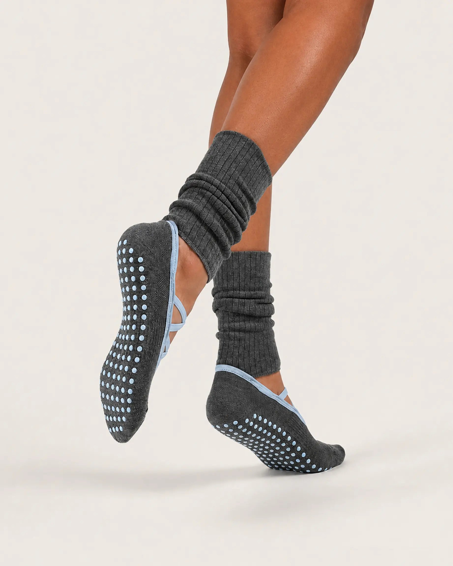 charcoal-blue | 04 | Charcoal blue crisscross strap slouch grip socks action view showing the silicone full-sole grip, open instep, and light blue straps