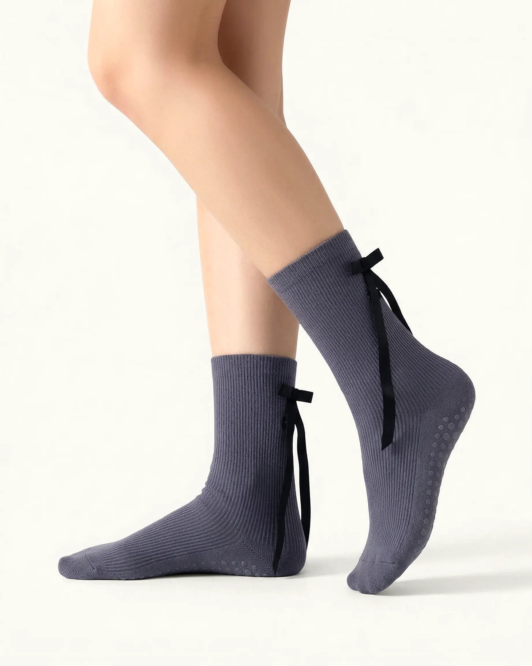 dark-grey | 01 | Dark grey ballet ribbon crew grip socks side standing view showing ribbed knit texture, long ribbon bow detail, and ballet-inspired crew silhouette