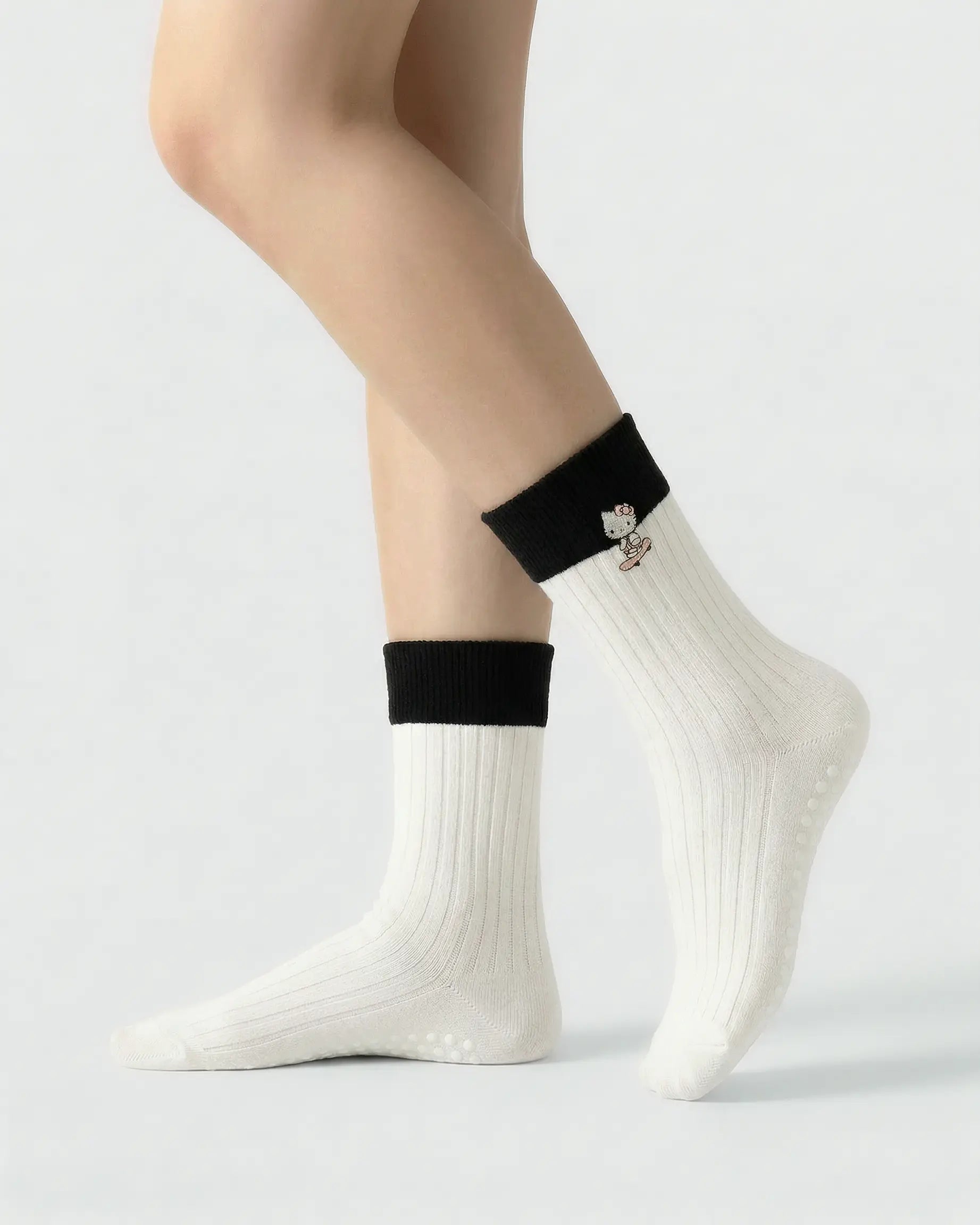 white | 01 | White character embroidery crew grip socks side standing view showing contrast black cuff, ribbed knit texture, and cat embroidery detail