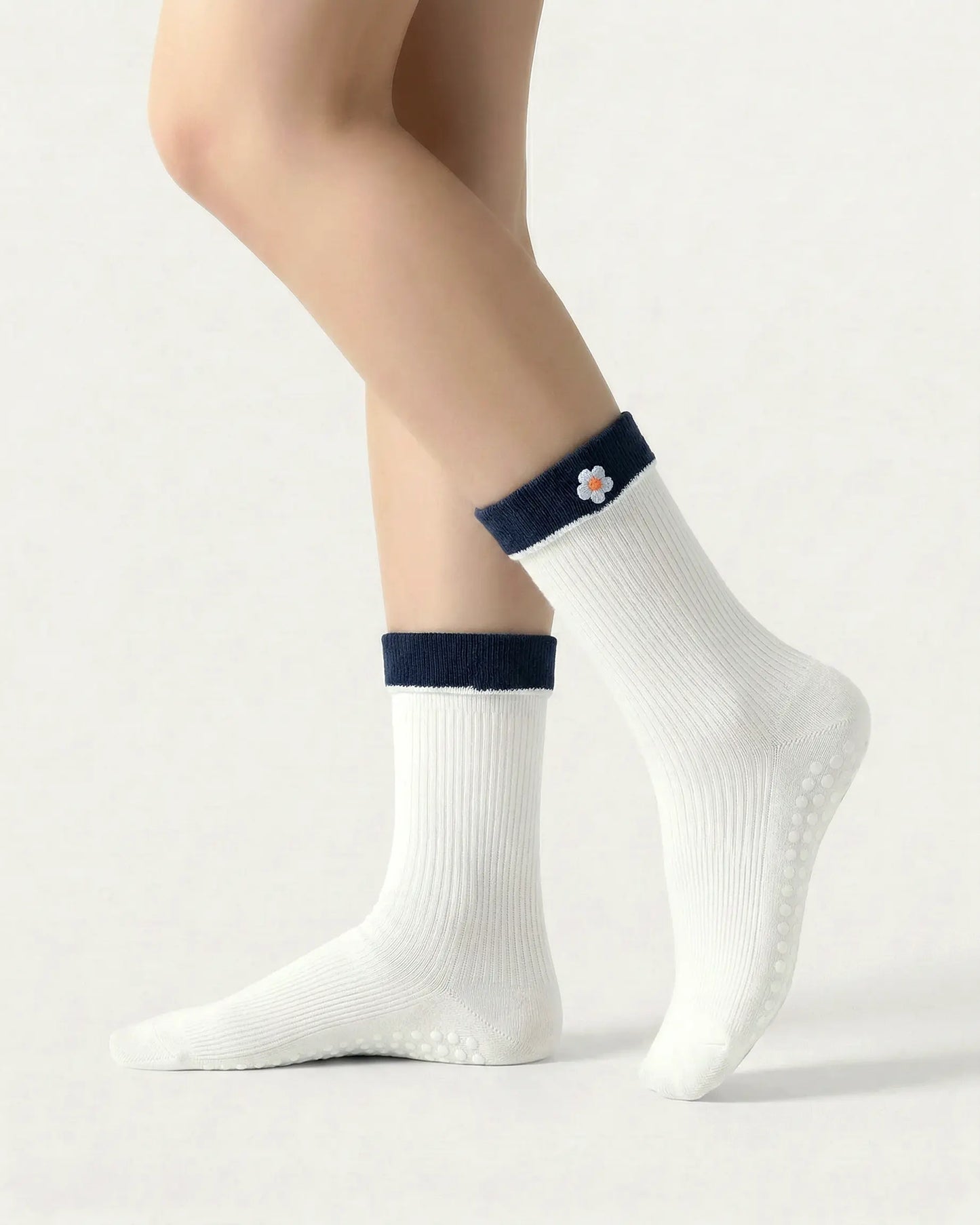 white | 01 | White floral detail crew grip socks side standing view showing contrast cuff, ribbed knit texture, and small flower embroidery detail