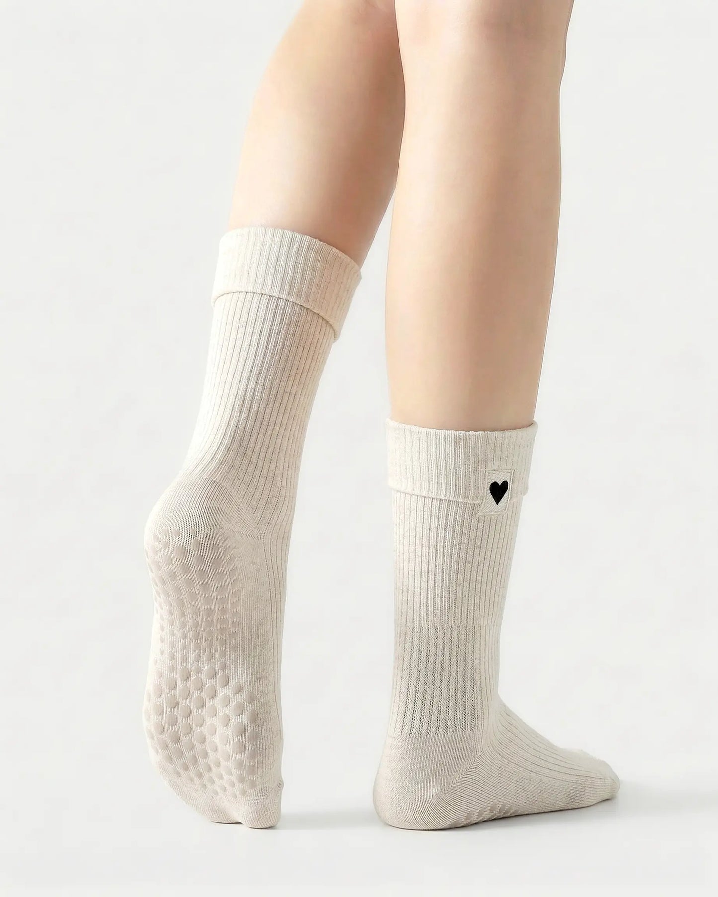 white | 02 | White heart detail crew grip socks back side view showing grip sole detail, fold-over cuff, and black heart embroidery