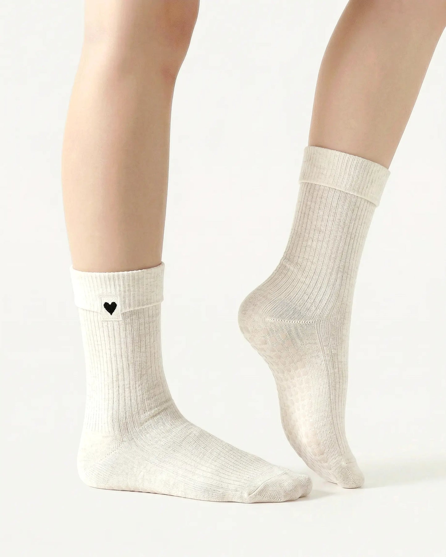 white | 03 | White heart detail crew grip socks side pointed standing view showing crew length, ribbed texture, and minimal studio styling