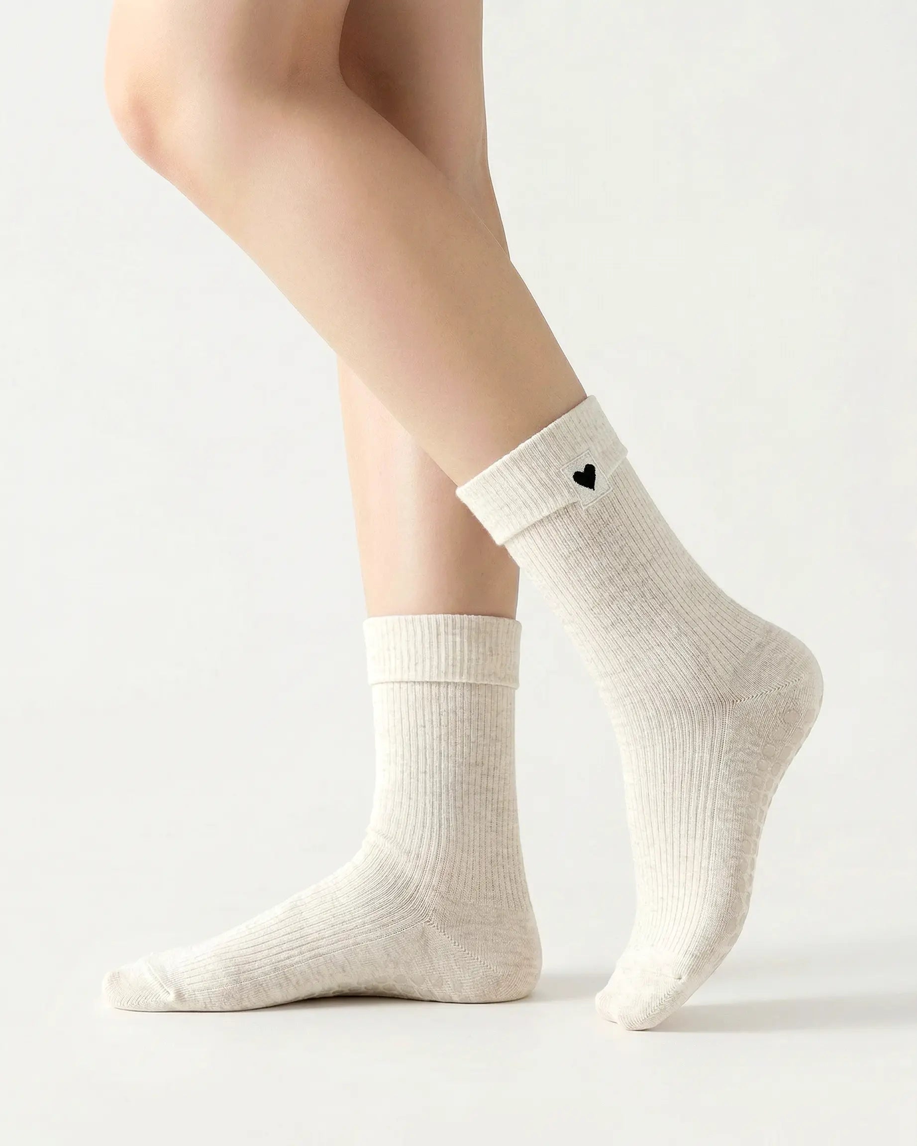 white | 01 | White heart detail crew grip socks side standing view showing ribbed knit texture, fold-over cuff, and black heart embroidery